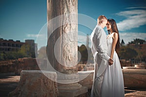 Ethereal, divine bride with shiny dress and groom standing near