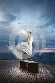 Ethereal, divine, unreal bride lfly like a bird from ocean pier.