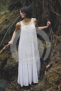 Ethereal young woman in dark forest