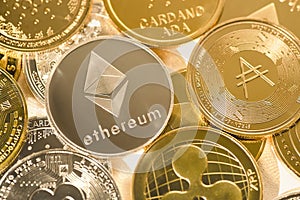 Ethereum silver coin against the background of other golden coins. Electronic virtual cryptocurrency for online banking.