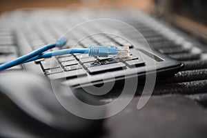 Ethernet cable plug connector on computer laptop keyboard technology concept