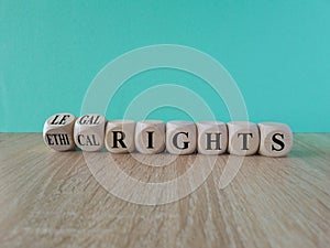 Ethical or legal rights symbol. Turned wooden cubes and changes words ethical rights to legal rights on a beautiful blue