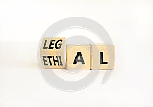 Ethical or legal symbol. Businessman turns wooden cubes and changes the word Ethical to Legal on a Beautiful white table white