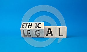 Ethical and Legal symbol. Turned wooden cubes with words Ethical and Legal. Beautiful blue background. Business and Ethical and