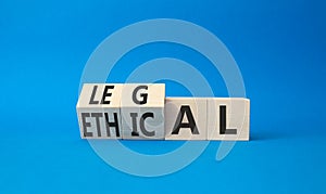Ethical and Legal symbol. Turned wooden cubes with words Ethical and Legal. Beautiful blue background. Business and Ethical and