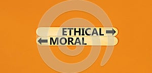 Ethical or moral symbol. Concept word Ethical or Moral on beautiful wooden stick. Beautiful orange table orange background.