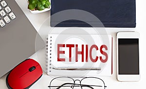 ETHICS text on notepad,pen, office tools on the white background. Business concept