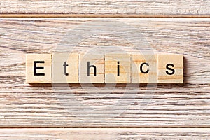 Ethics word written on wood block. Ethics text on table, concept