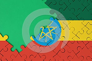 Ethiopia flag is depicted on a completed jigsaw puzzle with free green copy space on the left side