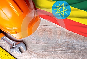 Ethiopia flag with different construction tools on wood background, with copy space for text