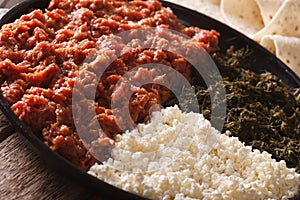 Ethiopian kitfo with herbs and cheese ayibe close-up. horizontal