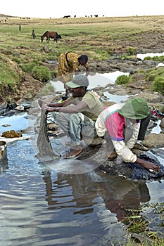 Ethiopians washing clothes in a running stream