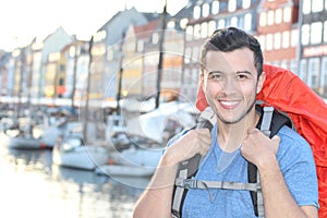 Ethnic backpacker smiling in the epic Nyhavn, Copenhagen, Denmark