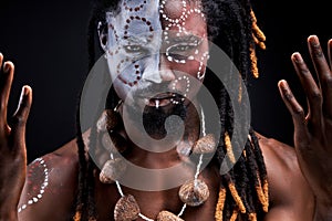 ethnic black male model doing ritual isolated over black background