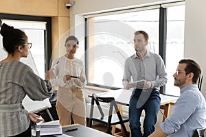 Ethnic businesswoman lead meeting with diverse employees