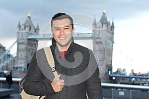 Ethnic elegant man walking around London bridge