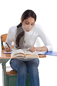 Ethnic Indian college student by desk in class