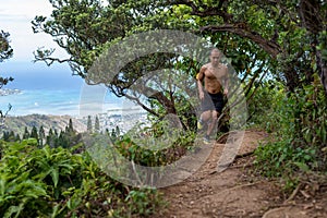Ethnic man trail running atop ridge trail without a shirt