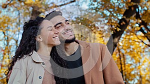 Ethnic multiracial married couple in autumn park happy smiling Caucasian woman with Hispanic man outdoors guy and girl