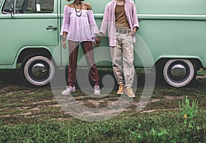 Ethnicity couple holding hands near retro van