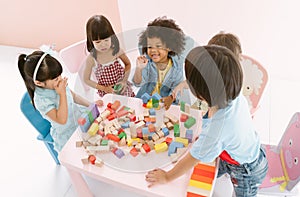 Ethnicity diversity group of kids playing with colorful blocks on table in class at the kindergarten. Kindergarten international