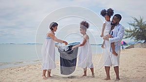 Ethnicity Happy asian and africans american Family picking up garbage activity on the beach photo