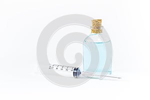 Ethyl alcohol in glass bottle with single use syringe isolate on white background