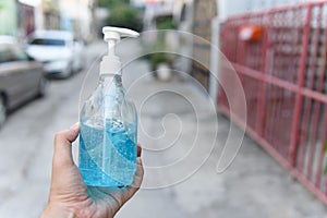 Ethyl Alcohol hand gel in a hand on the street in front of the house, concept for coronavirus, covid19