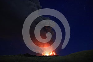 L\'Etna in Sicilia grande eruzione con grandi emissioni di cenere dal cratere del vulcano nel ciel notturno stellato photo