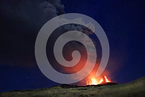 L'Etna in Sicilia grande eruzione con grandi emissioni di cenere dal cratere del vulcano nel ciel notturno stellato