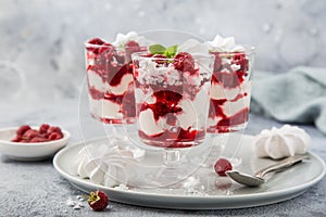 Eton mess, traditional english dessert, meringues, whipped cream, berry sauce and fresh raspberry in  glass