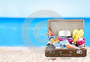 Etro suitcase with travel objects on tropical