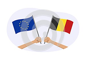 EU and Belgium flags. Belgian and European Union symbols. Hand holding waving flag. Vector illustration