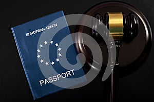 EU citizens rights and european freedom of movement concept with close up on an european passport next to a gavel on a dark photo