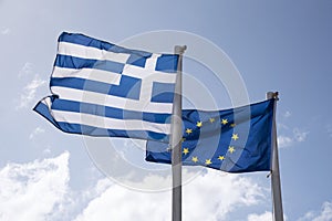 EU community flag and the national flag of Greece flying from poles