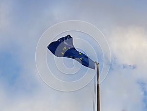 EU European Union Flag waving on pole in the wind on clear blue sky background