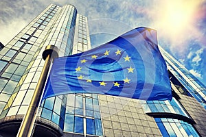 EU flag waving in front of European Parliament building in Bruss