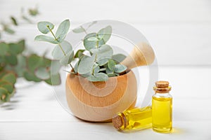 Eucalyptus leaves and mortar on a wooden background.