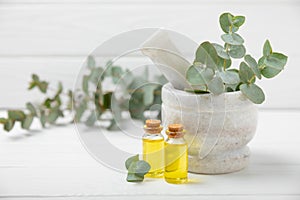 Eucalyptus leaves and mortar on a wooden background.