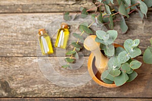 Eucalyptus leaves and mortar on a wooden background.