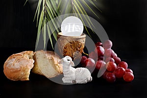 Eucharist symbol with bread  grape and holy host on black background photo