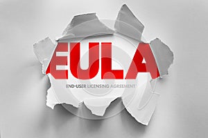 EULA end user licensing agreement text shown through torn paper surface, software legal concept describing usage terms,