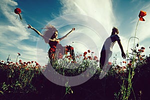 Euphoria. man and girl in red poppy field