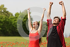 Euphoric couple raising arms in the country photo