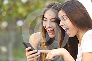 Euphoric friends watching videos on a smartphone photo