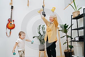 Euphoric granny doing phisical exercises with her grandson, tries to encourage