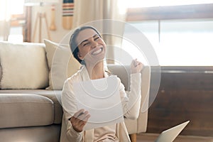 Euphoric happy young european woman reading paper document.