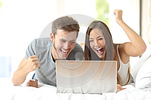 Euphoric marriage winning with a laptop at home photo