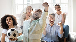 Euphoric mixed race people watching sport championship on tv.