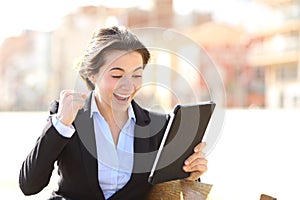 Euphoric successful executive watching a tablet photo